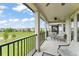Spacious covered balcony with comfortable seating and a view of the community green space at 1787 White Feather Loop, Oakland, FL 34787