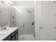 Contemporary bathroom showcasing double vanity and walk-in shower with a rainfall showerhead and tiled surround at 1787 White Feather Loop, Oakland, FL 34787