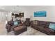 Cozy living area with leather furniture and an open view to the kitchen at 1787 White Feather Loop, Oakland, FL 34787