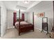 Spacious main bedroom with tray ceiling, four poster bed, side table and decorative wall art at 1787 White Feather Loop, Oakland, FL 34787