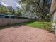 Large backyard with a brick patio, green lawn, and a wooden fence at 2100 Forest Cir, Orlando, FL 32803