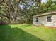 Spacious backyard with a lush lawn and mature trees, offering privacy at 2100 Forest Cir, Orlando, FL 32803