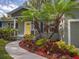 Close-up of home's entrance showcasing landscaping with mature palm trees and a bright yellow front door at 2100 Forest Cir, Orlando, FL 32803