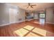 Sunlit living room with hardwood floors, ceiling fan, and access to the kitchen and dining area at 2100 Forest Cir, Orlando, FL 32803