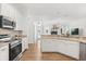 Bright, open kitchen featuring white cabinets and a stainless steel appliance package at 218 Pebblerock Ct, Orlando, FL 32828
