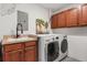 Well-organized laundry area featuring washer, dryer, cabinets, and sink at 218 Pebblerock Ct, Orlando, FL 32828