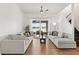 Bright living room featuring wood floors, two sofas, ceiling fan and sliding glass doors to an outdoor seating area at 218 Pebblerock Ct, Orlando, FL 32828