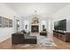 Bright living room featuring a dark gray sectional, fireplace with marble surround, and entertainment center at 218 Pebblerock Ct, Orlando, FL 32828