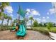 Community playground with green slide and shade structure, set against a backdrop of trees and blue sky at 2233 Valentine Aly, Orlando, FL 32804