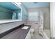 Bright bathroom with marble tile and a dark countertop vanity and shower/tub combo at 2325 E Harding Street, Orlando, FL 32806