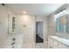 Bright bathroom features a marble-tiled shower, soaking tub, and updated vanity at 2325 E Harding Street, Orlando, FL 32806
