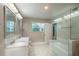 Bathroom features a double vanity with a marble countertop and glass-enclosed tub at 2325 E Harding Street, Orlando, FL 32806