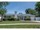 Charming one story home boasts a well-manicured lawn, mature landscaping, and neutral color palette at 2325 E Harding Street, Orlando, FL 32806