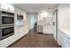 This kitchen features white cabinets, stainless steel appliances, and wood floors at 2325 E Harding Street, Orlando, FL 32806