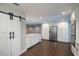 Spacious kitchen featuring white cabinetry, quartz countertops, stainless steel appliances and a barn door at 2325 E Harding Street, Orlando, FL 32806