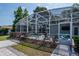 A screened enclosed pool in a backyard with a stone patio, landscaping, and outdoor seating at 2325 E Harding Street, Orlando, FL 32806