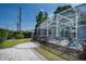 Enclosed pool with a screened enclosure, stone patio, and well-maintained landscaping at 2325 E Harding Street, Orlando, FL 32806