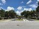 Gated entrance to a residential community featuring lush landscaping and well-maintained surroundings under a bright sky at 2826 Osprey Cove Pl # 103, Kissimmee, FL 34746
