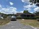 Inviting single-Gathering home with a screened porch and gravel driveway, offering a blend of comfort and practicality at 3411 Hughey St, Sanford, FL 32771