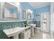 Stylish bathroom with dual sinks, mosaic tile accents, and an abundance of natural light at 3618 Rothbury Dr, Belle Isle, FL 32812