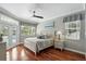 Comfortable bedroom with hardwood floors, ceiling fan, and views of the outdoors at 3618 Rothbury Dr, Belle Isle, FL 32812