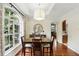 Bright dining room with hardwood floors, large window and modern lighting fixture above a wood table at 3618 Rothbury Dr, Belle Isle, FL 32812