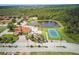 A high angle view of the community amenities including a swimming pool, playground, and tennis courts by the pond at 436 Caraway Dr, Kissimmee, FL 34759