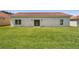Spacious backyard featuring a well-maintained lawn and the home's back exterior at 436 Caraway Dr, Kissimmee, FL 34759