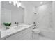 Modern bathroom with dual vanity, marble tile, toilet, and bathtub with shower at 436 Caraway Dr, Kissimmee, FL 34759