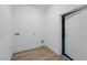 Clean laundry room features wood-look flooring, a white door, and white walls at 436 Caraway Dr, Kissimmee, FL 34759