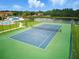 Well-maintained tennis court within a gated community, surrounded by lush greenery at 436 Caraway Dr, Kissimmee, FL 34759