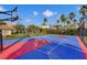 Community basketball court with colorful playing surface, surrounded by greenery and palm trees at 5012 Shoreway Loop # 10107, Orlando, FL 32819