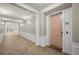 Well-lit hallway with tiled floors, wainscoting and a view of unit 101, for a clean and navigable residential experience at 5012 Shoreway Loop # 10107, Orlando, FL 32819