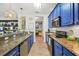 Galley kitchen featuring granite countertops, stainless appliances, and stylish cabinetry at 5012 Shoreway Loop # 10107, Orlando, FL 32819