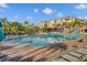 A large community pool and deck feature lounge chairs and umbrellas against the backdrop of a multi-story building at 5012 Shoreway Loop # 10107, Orlando, FL 32819