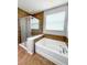Bathroom featuring a glass enclosed shower, separate tub, and tile surround at 5107 Longmeadow Park St, Orlando, FL 32811