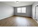 Bedroom boasts natural light through a large window, enhancing the wood-look flooring at 5107 Longmeadow Park St, Orlando, FL 32811