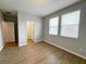 Bedroom featuring wood look floors, gray walls, two windows and closet at 5107 Longmeadow Park St, Orlando, FL 32811