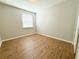 Bright bedroom features wood-look flooring and a window with blinds for ample natural light at 5107 Longmeadow Park St, Orlando, FL 32811