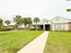 Inviting clubhouse featuring a sidewalk and lush green space with palm trees, and a pool nearby at 5107 Longmeadow Park St, Orlando, FL 32811