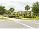 Scenic community entrance with lush landscaping, palm trees, and charming neighborhood residences at 5107 Longmeadow Park St, Orlando, FL 32811