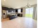 Bright kitchen with stainless steel appliances, dark cabinetry, granite countertops, and tile flooring at 5107 Longmeadow Park St, Orlando, FL 32811