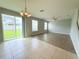 Open concept living room with hard surface flooring, tile, a ceiling fan, and large glass sliding door at 5107 Longmeadow Park St, Orlando, FL 32811