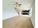 Open-concept living room with hardwood floors, fan, and an open flow to the kitchen and staircase at 5107 Longmeadow Park St, Orlando, FL 32811
