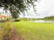 Picturesque view of pond with lush green lawn and playground area at 5107 Longmeadow Park St, Orlando, FL 32811