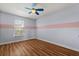 Bedroom with wood floors features a ceiling fan and single window at 5200 Sunset Canyon Dr, Kissimmee, FL 34758