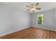 This bedroom features wood floors, a ceiling fan, and a bright window at 5200 Sunset Canyon Dr, Kissimmee, FL 34758