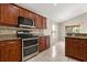 The kitchen features wooden cabinets, stainless steel appliances, and a tiled floor at 5200 Sunset Canyon Dr, Kissimmee, FL 34758