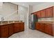 Kitchen with wood cabinets, tile flooring, and granite countertops, adjacent to the staircase at 5200 Sunset Canyon Dr, Kissimmee, FL 34758