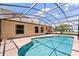 Backyard view of an in-ground swimming pool with screen enclosure and blue skies at 5200 Sunset Canyon Dr, Kissimmee, FL 34758